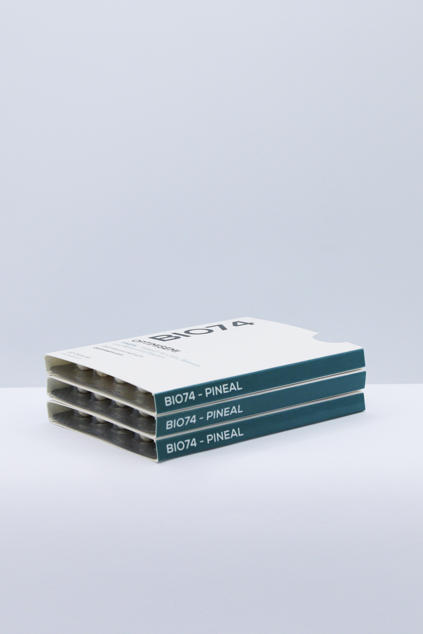 Iimage shows three stacked boxes of BIO74 – PINEAL supplements by OPTIMISEMI, designed to support the pineal gland, with a clean, minimalist packaging that reflects a focus on wellness and targeted health.