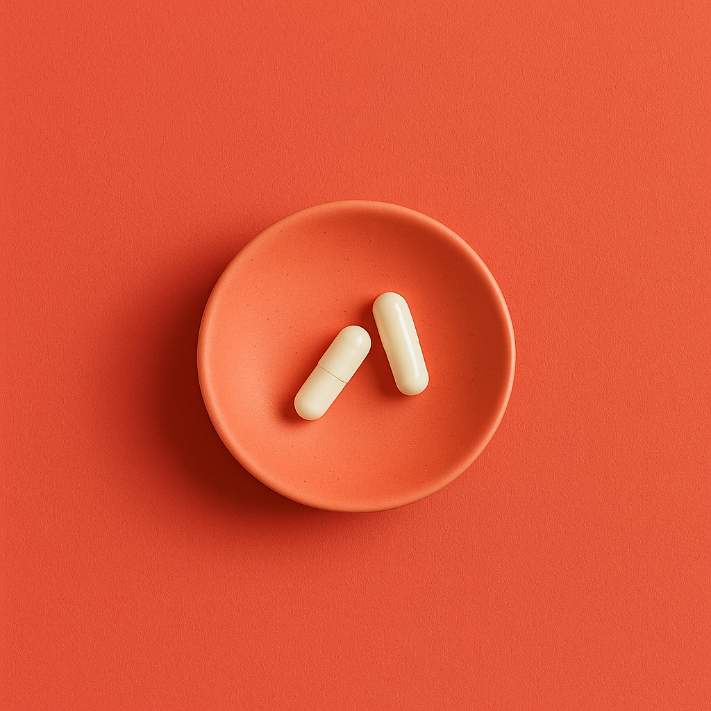 Two white optimisemi supplement capsules on a coral plate against a coral background